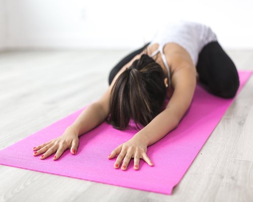 Group of people stretching on yoga mats, improving mobility